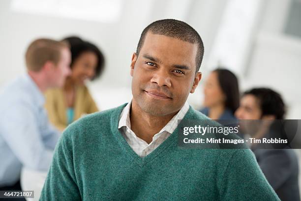 an office in the city. business. team meetings. a group sitting down around a table. one person in the foreground. a man smiling confidently. - indian woman short hair stock pictures, royalty-free photos & images