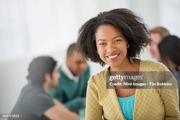 an office in the city. business. team meetings. a group sitting down around a table. one person in the foreground. a confident businesswoman. leader. - indian woman short hair stock pictures, royalty-free photos & images