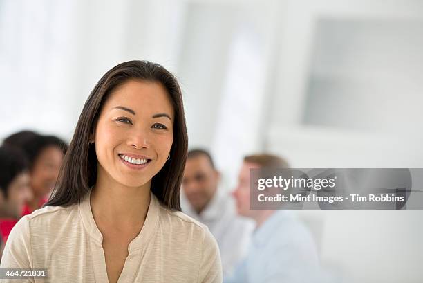 an office in the city. business. team meetings. a group sitting down around a table. one person in the foreground. a confident businesswoman. leader. - indian woman short hair stock pictures, royalty-free photos & images