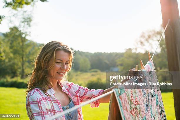 a woman hanging laundry on the washing line,in the fresh air. - woodstock new york stockfoto's en -beelden