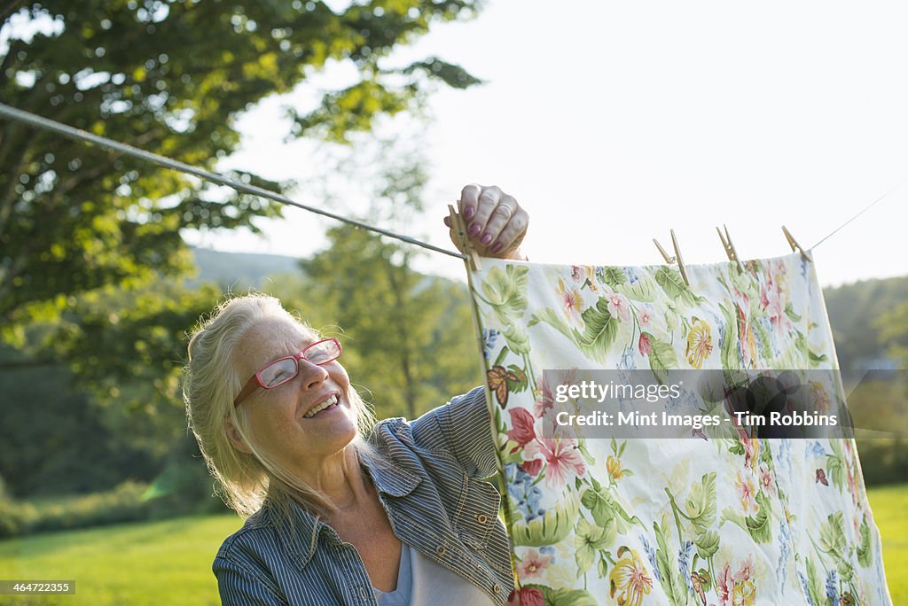 A woman hanging laundry on the washing line,in the fresh air.