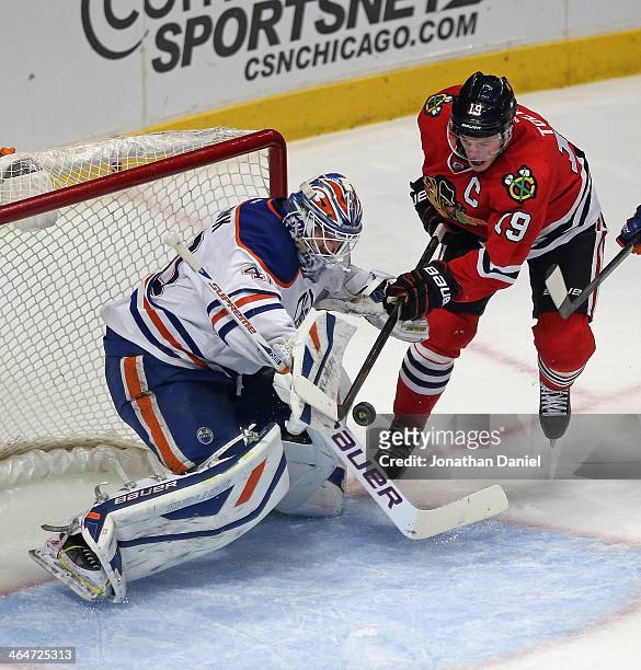 Devan Dubnyk of the Edmonton Oilers makes a save against Jonathan Toews of the Chicago Blackhawks at the United Center on January 12, 2014 in...