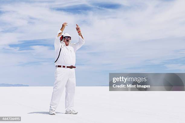 a man in white overalls,with a radio headset,a race official timekeeper at a car racing event,speed week. - starter foto e immagini stock