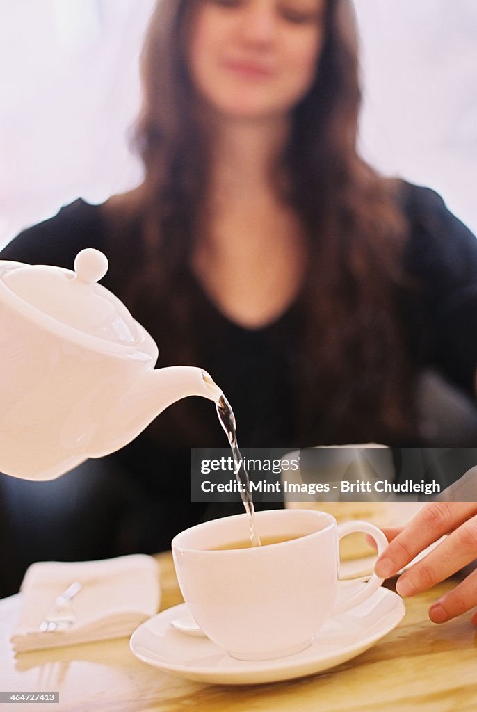 A woman pouring a cup of tea