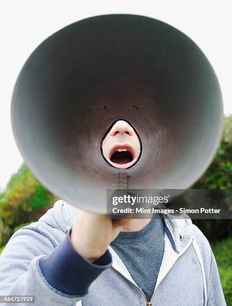 a man using a megaphone in the open air. - man open mouth stock pictures, royalty-free photos & images