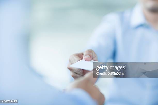 close up of two businessmen exchanging business cards - business card stock pictures, royalty-free photos & images