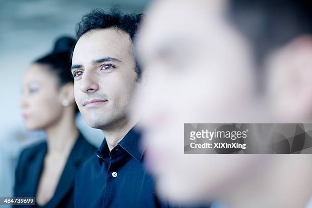young businessman sitting in a business meeting with colleagues - listening skills stock pictures, royalty-free photos & images