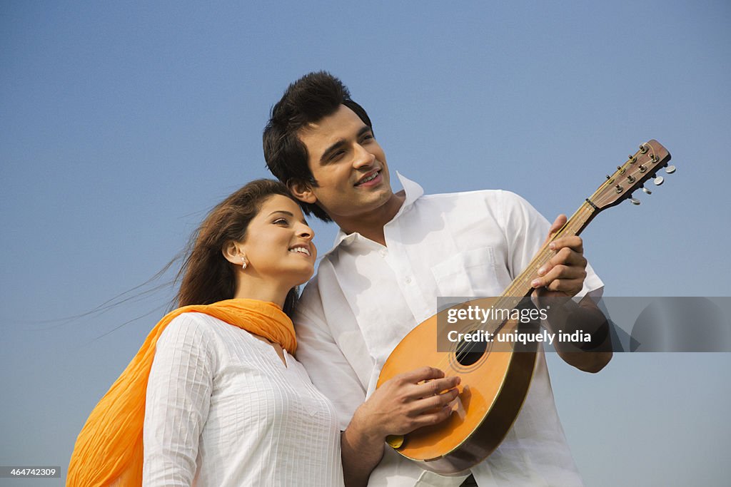 Couple playing a mandolin and smiling