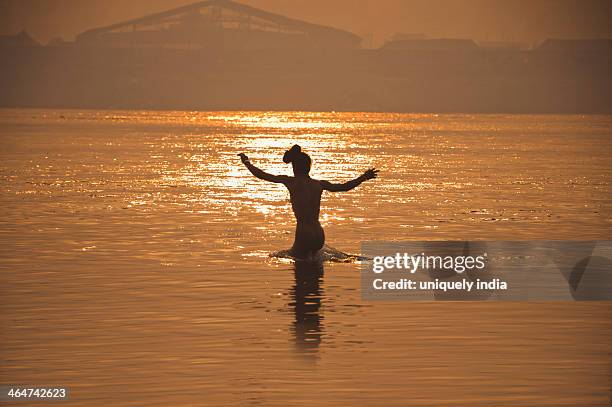 sadhu having a morning bath in ganges river at maha kumbh, allahabad, uttar pradesh, india - allahabad ストックフォトと画像