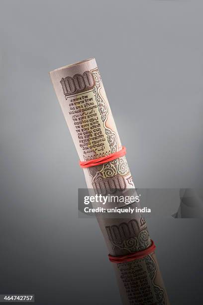 close-up of rolled one thousand indian banknote - indian rupee note stock pictures, royalty-free photos & images