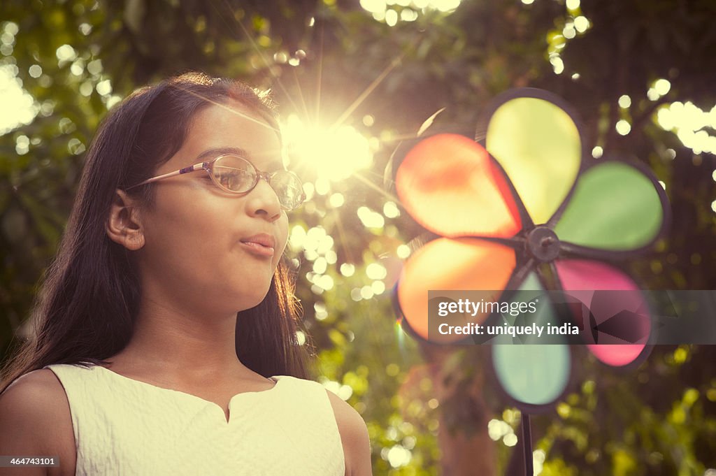 Close-up of a girl blowing a pin wheel