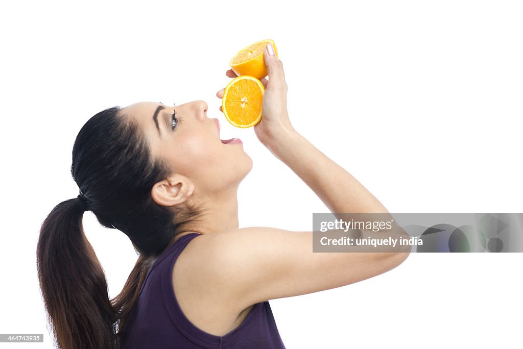 Woman drinking juice from an orange