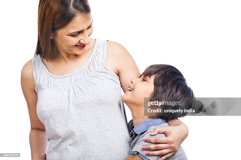 Close-up of a woman hugging her son and smiling