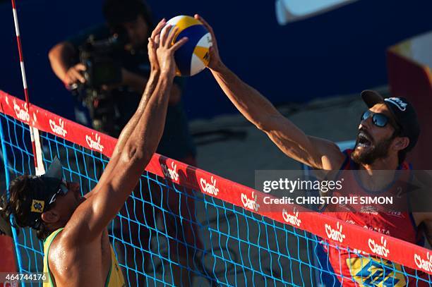 WITh AFP STORY BY LOUIS GENOT Ricardo from Brazil blocks the spike of US Brunner during their "Best of the world" beach volley match in Copacabana...