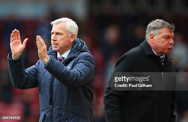 Alan Pardew manager of Crystal Palace celebrates victory as Sam Allardyce manager West Ham United look dejected after the Barclays Premier League...
