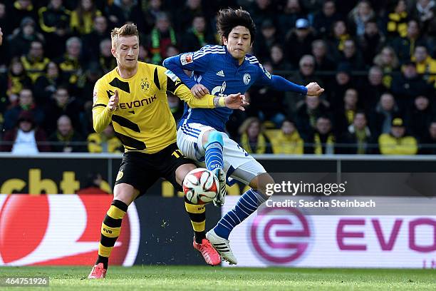 Marco Reus of Dortmund and Atsuto Uchida of Schalke battle for the ball during the Bundesliga match between Borussia Dortmund and FC Schalke 04 at...