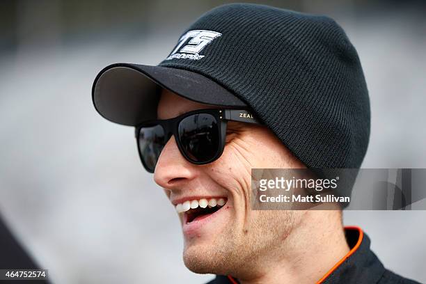 James Buescher, driver of the NTS Motorsports Chevrolet, stands on the grid during qualifying for the NASCAR Camping World Truck Series Hyundai...
