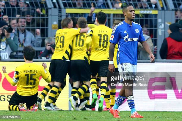 Dennis Aogo of Schalke looks dejected whilst players of Dortmund celebrate the first team goal during the Bundesliga match between Borussia Dortmund...