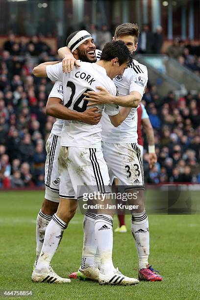 Jack Cork of Swansea City is congratulated by teamates after his shot is deflected for an own goal during the Barclays Premier League match between...
