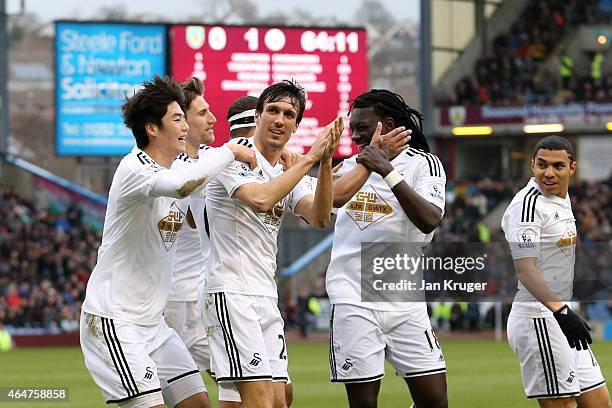 Jack Cork of Swansea City is congratulated by teamates after his shot is deflected for an own goal during the Barclays Premier League match between...