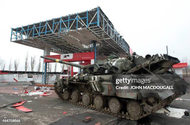 Damaged Ukrainian army tank is immobilised in a wrecked petrol station outside the eastern Ukrainian city of Debaltseve in Donetsk region, on...