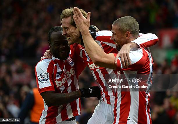Peter Crouch of Stoke City celebrates scoring the first goal with team-mates Victor Moses and Jonathan Walters during the Barclays Premier League...