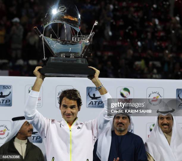 Roger Federer of Switzerland poses with the ATP Dubai Duty Free Tennis Championships trophy after defeating World number one Novak Djokovic of Serbia...