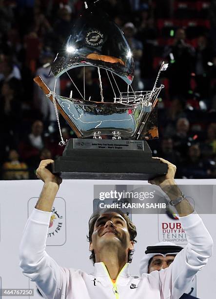 Roger Federer of Switzerland poses with the ATP Dubai Duty Free Tennis Championships trophy after defeating World number one Novak Djokovic of Serbia...