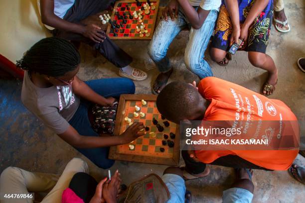 Year-old Phiona Mutesi plays a game of chess with her colleagues at the chess academy in Kibuye, Kampala, on January 26, 2015. When Phiona Mutesi was...