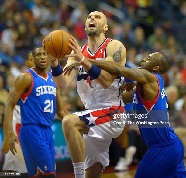 Washington center Marcin Gortat , center, is fouled by Philadelphia shooting guard James Anderson , right during the Washington Wizards defeat of the...