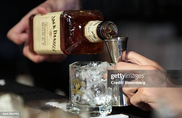 Bartender pours Jack Daniel's Tennessee Honey liqueur into a jigger during a media preview of the Jack Daniel's Lynchburg Barrel House, an official...