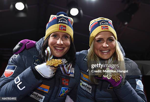 Gold medallist Therese Johaug of Norway poses with silver medallist Marit Bjoergen of Norway during the medal ceremony for the Women's 30km Mass...