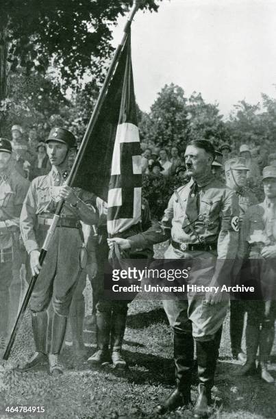 Adolf Hitler and Jakob Grimminger hold the Blutfahne at the 1929 Reichsparteitag flag consecration in Nuremberg, Germany, 4th August 1929. The...