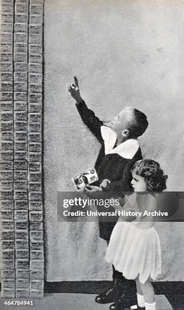 Hyperinflation in Germany post World War I: Children looking at a stack of thousands upon thousands of Deutschmarks which are not even worth the...