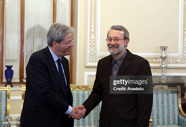 Iranian Parliamentary Speaker Ali Larijani and Italian Foreign Minister Paolo Gentiloni shake hands before a meeting held at the Parliament in...