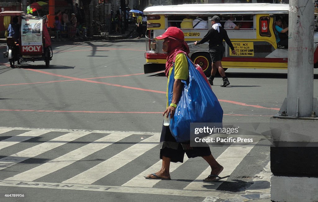 A man carries a large plastic bag containing recyclable...