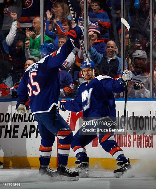 Michael Grabner of the New York Islanders celebrates his goal at 9:47 of the first period against the Carolina Hurricanes along with Johnny Boychuk...