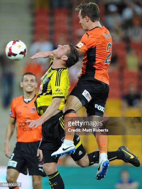 Matthew Smith of the Roar heads the ball over Benjamin Sigmund of the Phoenix during the round 16 A-League match between Brisbane Roar and the...