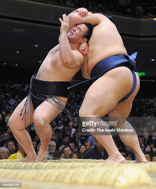 Satoyama throws Tochinowaka during day twelve of the Grand Sumo New Year Tournament at Ryogoku Kokugikan on January 23, 2014 in Tokyo, Japan.