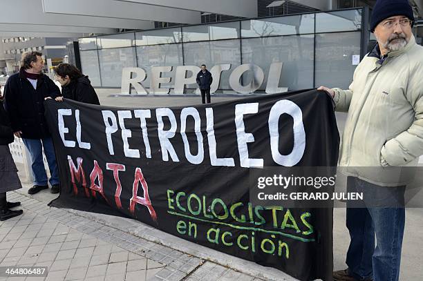 Environmentalist, members of the "Ecologistas en Accion" NGO, hold a banner reading in Spanish "Petrol kills" outside the main entrance to Spanish...