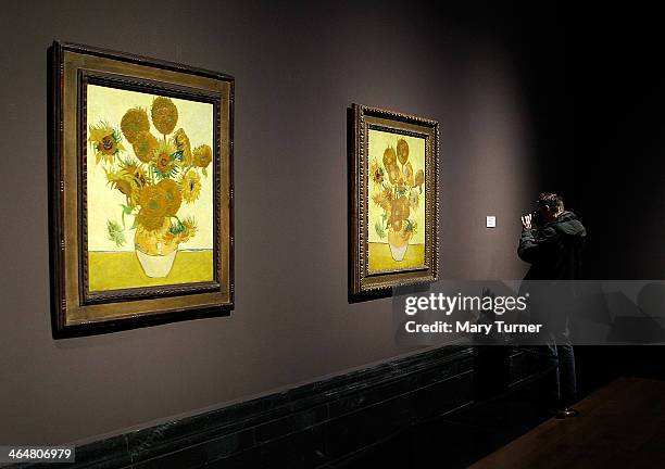 Photographer takes a picture of the display card beside one of Van Gogh's 'Sunflowers' which are on display in a new exhibition at the National...