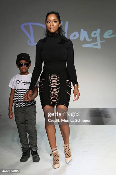 Designer LaToia Fitzgerald walks the runway with a model at the Dillonger show during petitePARADE / Kids Fashion Week at Bathhouse Studios on...