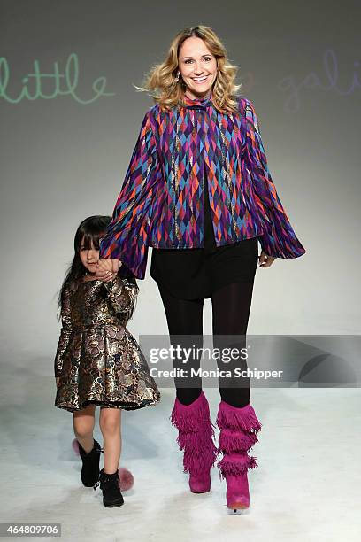 Designer Alia Charvel walks the runway with a model at the Little Miss Galia show during petitePARADE / Kids Fashion Week at Bathhouse Studios on...