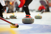 Sport of curling being played on a field