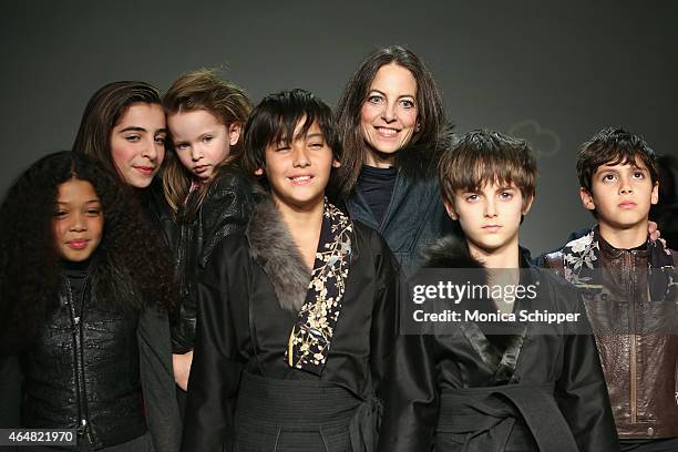 Designer Bonnie Young poses on the runway with her family and models at the Bonnie Young show during petitePARADE / Kids Fashion Week at Bathhouse...