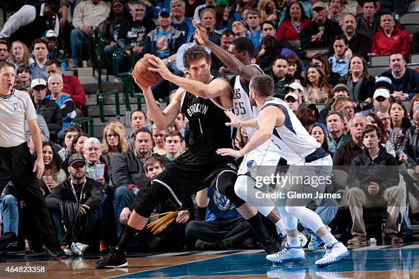 Brook Lopez of the Brooklyn Nets posts up against Bernard James of the Dallas Mavericks on February 28, 2015 at the American Airlines Center in...