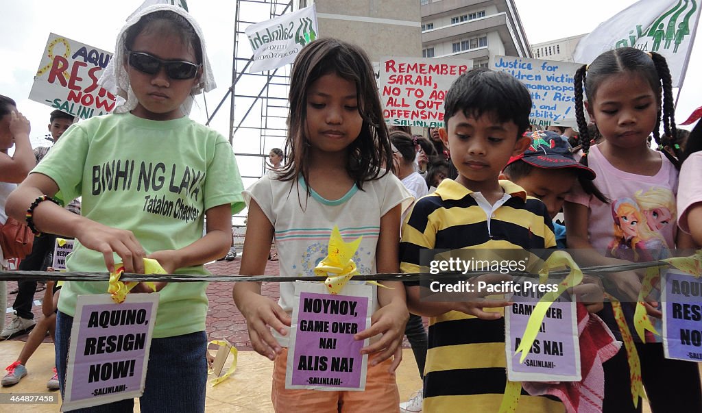 Filipino youth protesters tie placards with 'blood-stained'...