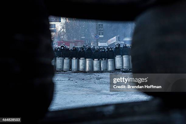 Line of police officers near Dynamo stadium is visible through a wall of tires on January 24, 2014 in Kiev, Ukraine. After two months of primarily...