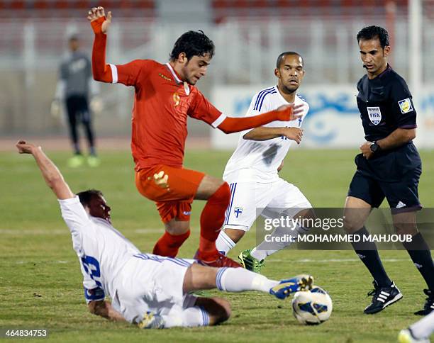 Omani player Abdullaziz al-miqbali fights for the ball with Teemu Tainio and Nicolai Alho of Finland during their friendly football match in the...