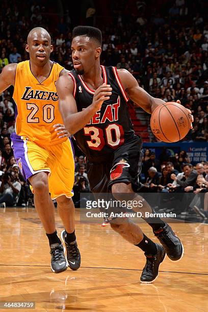 Norris Cole of the Miami Heat drives to the basket against Jodie Meeks of the Los Angeles Lakers at the American Airlines Arena in Miami, Florida on...